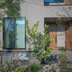 建物前には植栽が配置され、景観の美しさだけでなく、リビングの目隠しやタイルデッキに日陰を作ることで、快適な暮らしの空間を生み出しています。(外観)